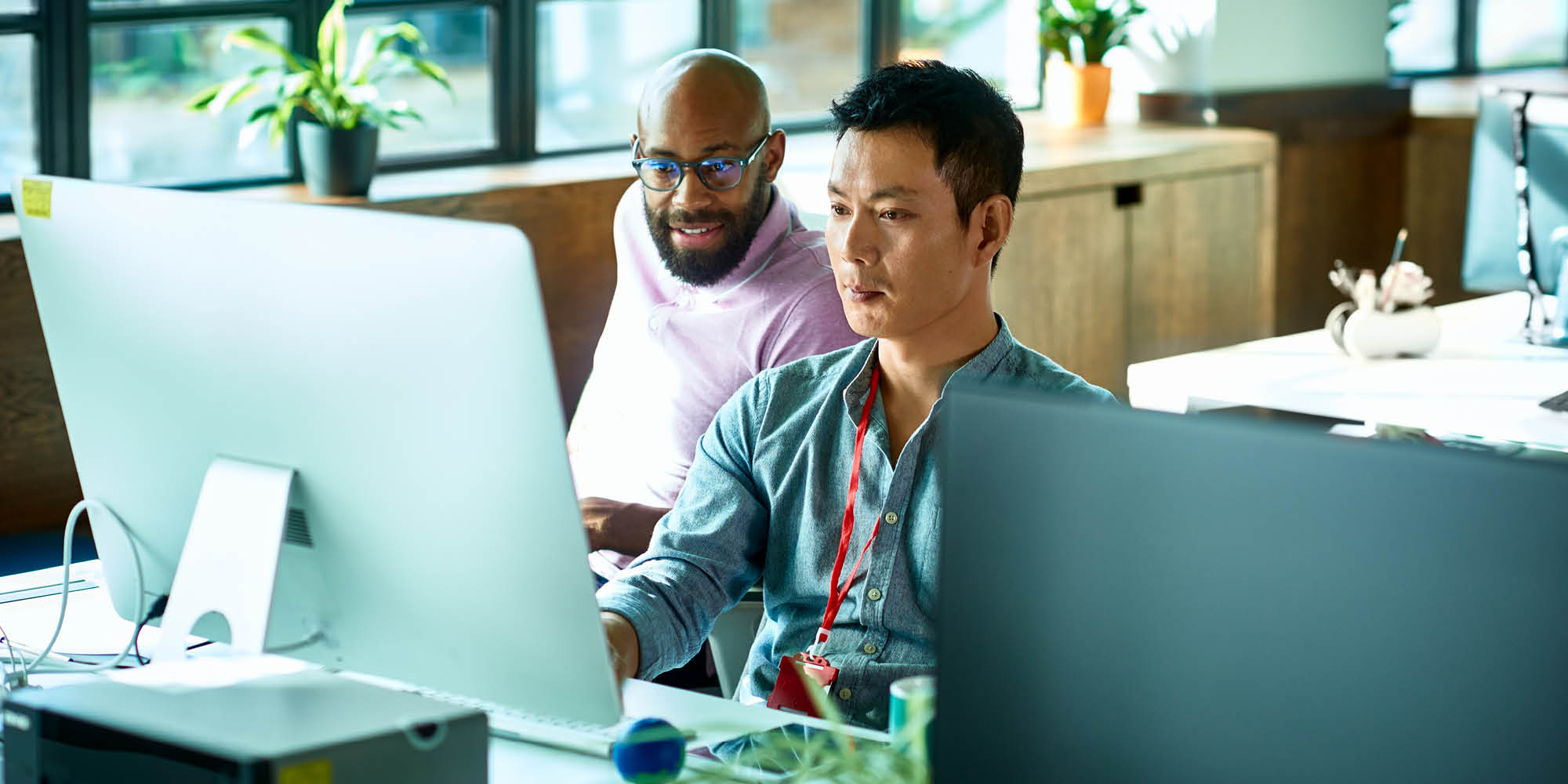 Two men looking at a computer screen in an office