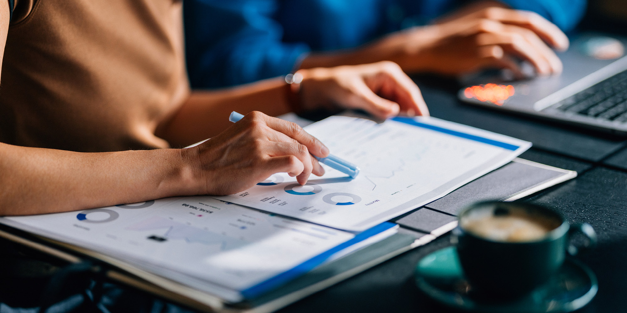 Close up image of a person pointing at chart with a pen